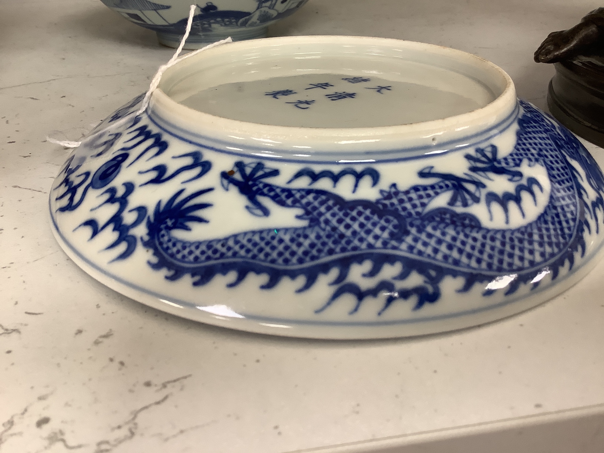 A Chinese blue and white landscape bowl, a/f and a Chinese blue and white ‘dragon’ dish, 18 and 16.5 cm